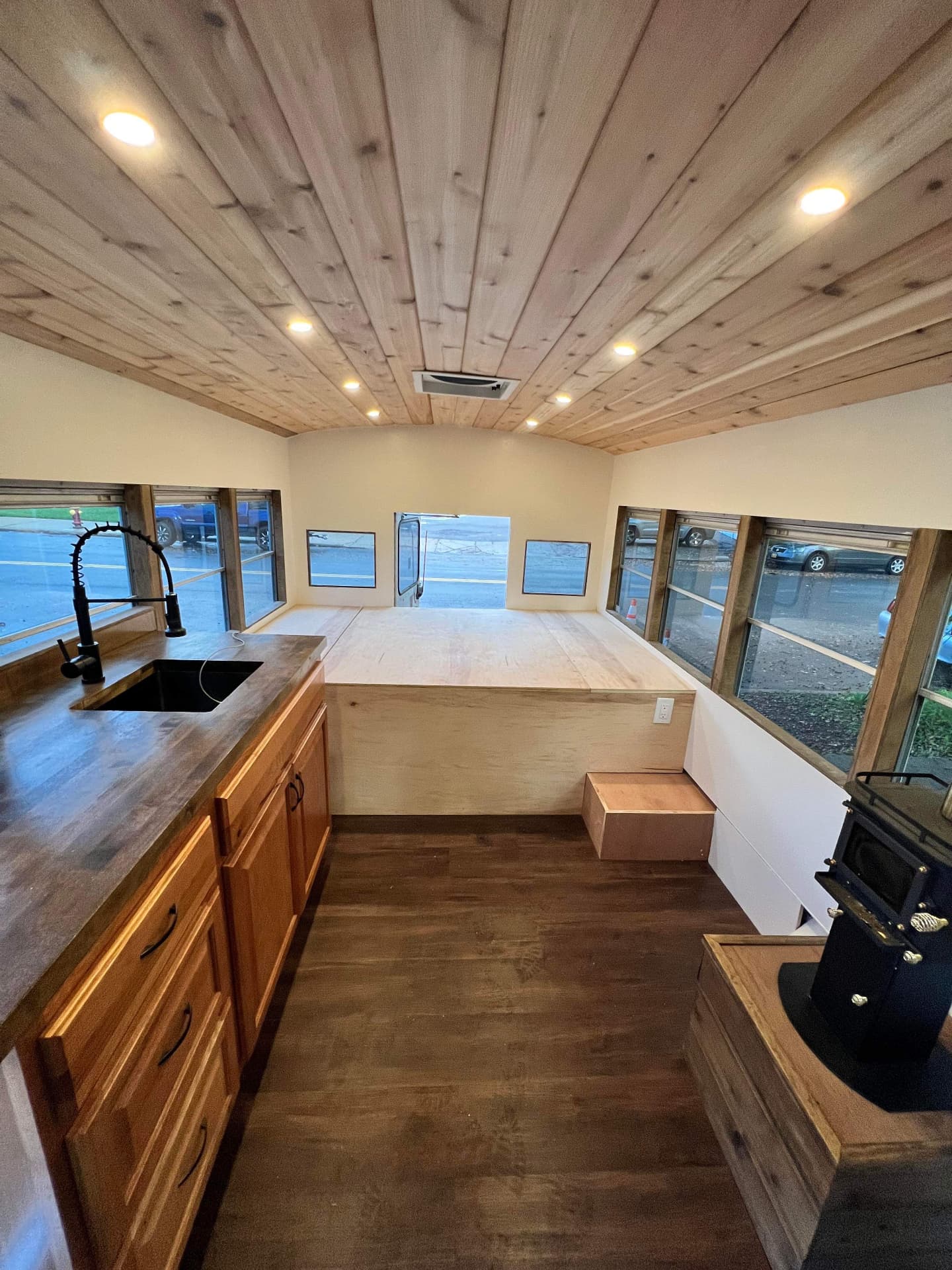 Skoolie conversion with wood ceiling and bed platform under construction