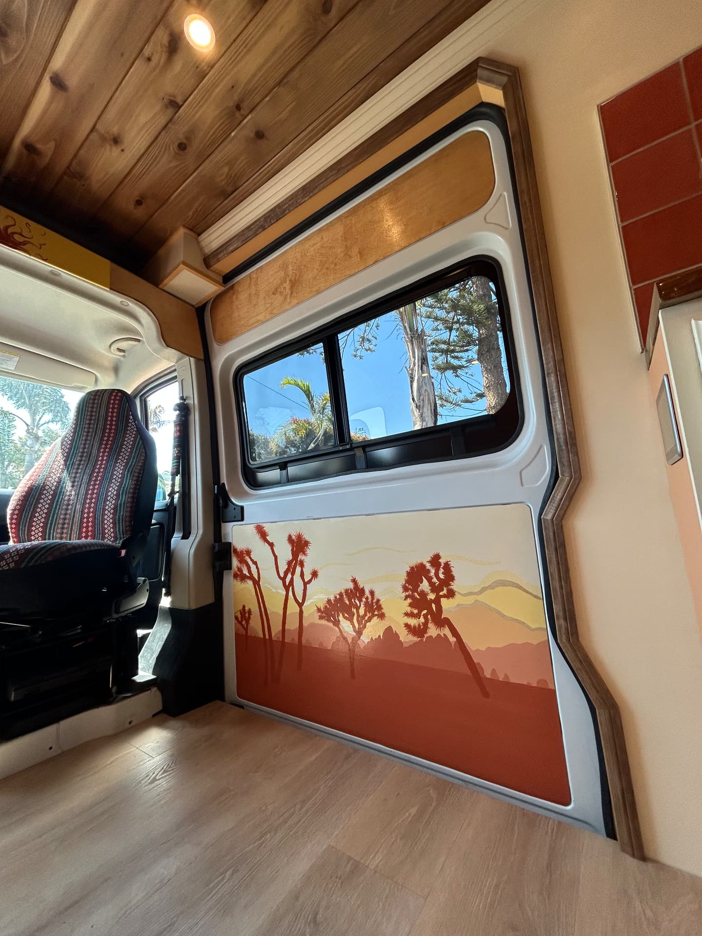Custom Joshua tree artwork door panel inside a camper van conversion