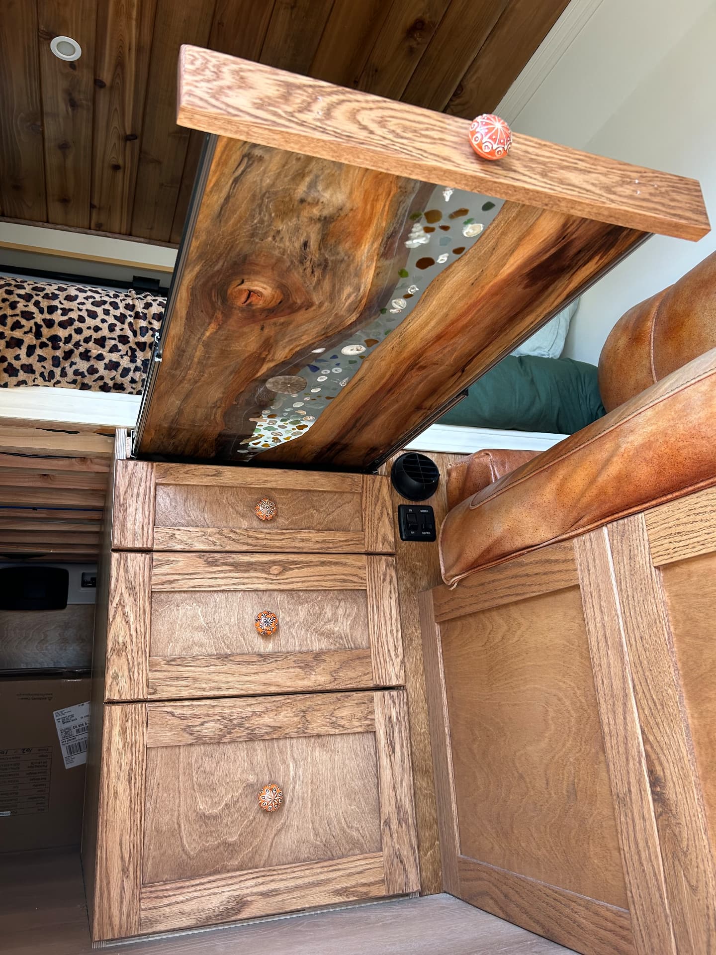 Custom walnut drawers with an epoxy resin river top inside a camper van build