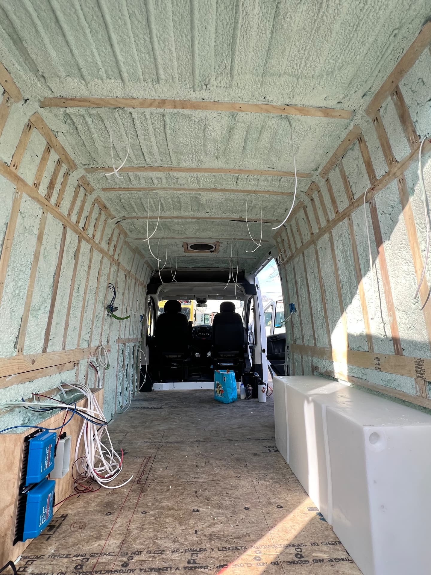 Camper van walls and ceiling insulated with spray foam and wood strapping during a build