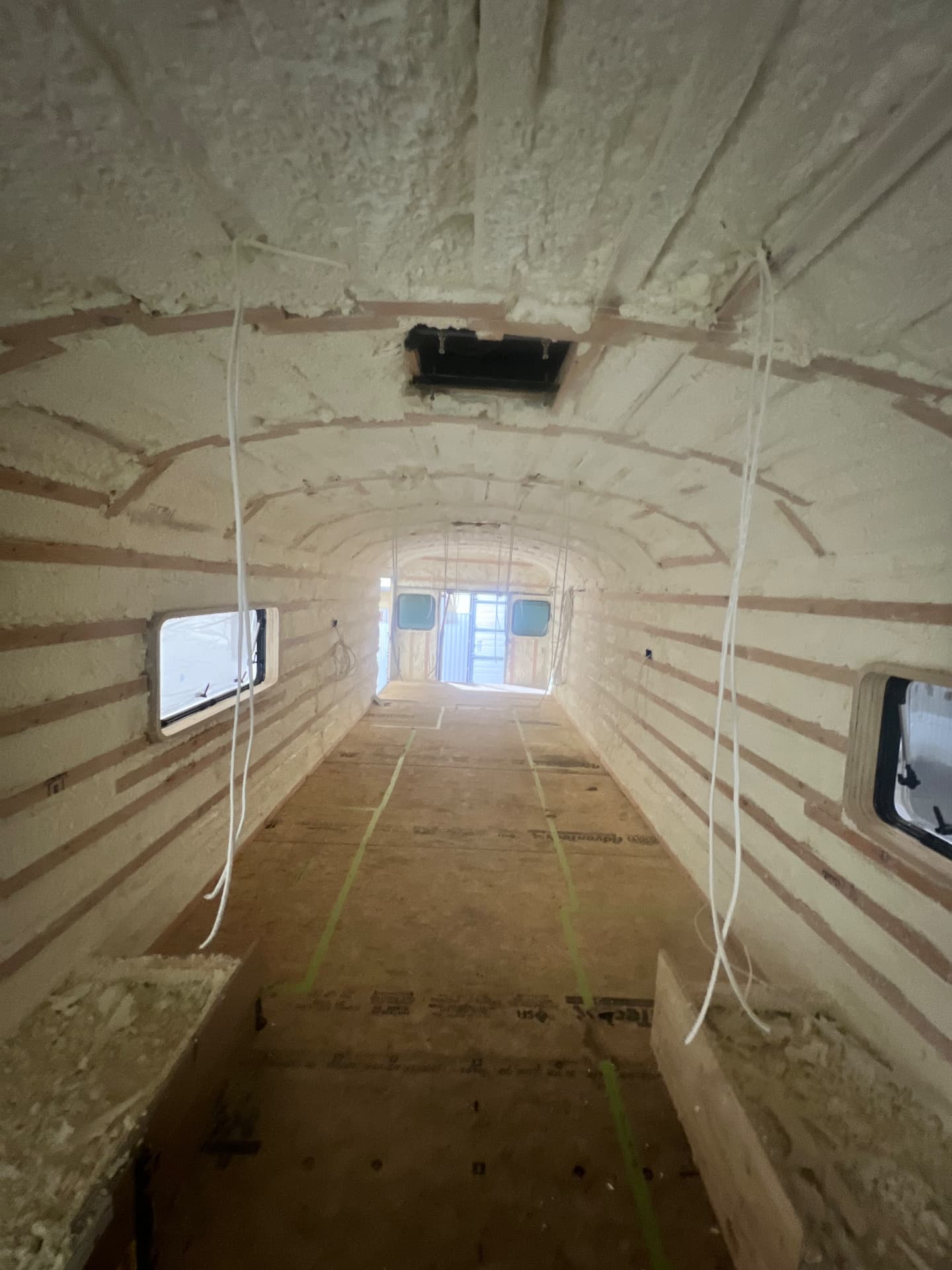 Skoolie conversion shell with electrical wiring runs and marked floor layout