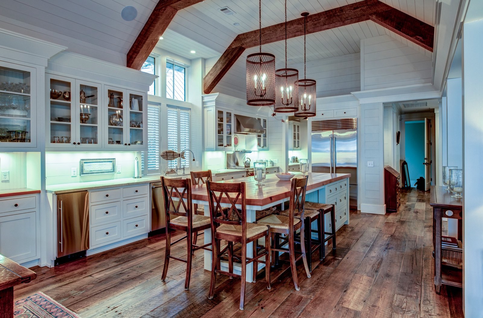 Large expensive chefs kitchen in luxury home with rough hewn wood and white cabinets.